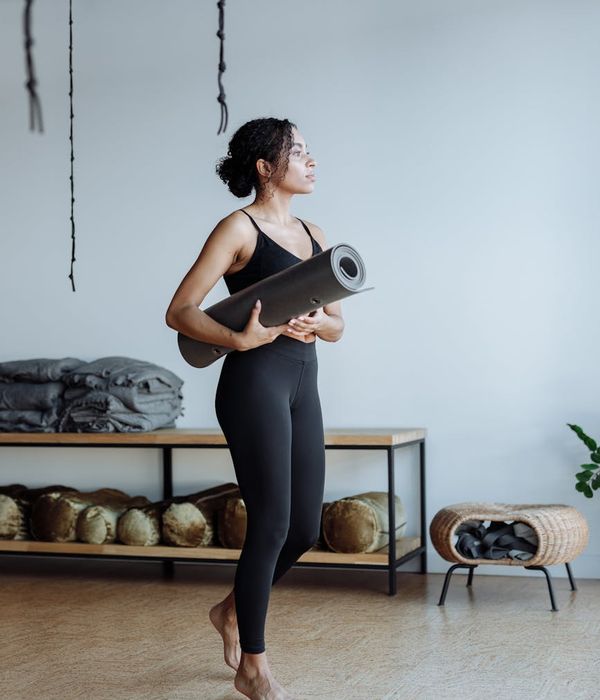 Woman holding a serene yoga pose in a cool-toned studio.